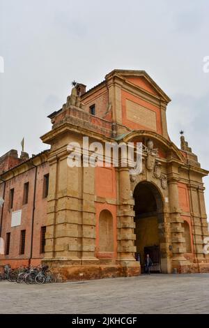 Un cliché vertical de la Porta Galliera avec des vélos garés sur le côté gauche et une personne marchant à Bologne, en Italie Banque D'Images