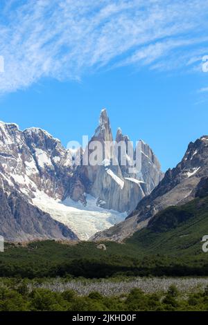 A vertical shot of the snowy Cerro Torre mountain surrounded with greenery in El Chalten, Argentina Stock Photo