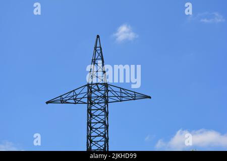 Une tour de transmission électrique haute tension sur fond bleu ciel Banque D'Images