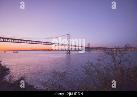 Une belle vue sur le pont suspendu Ponte 25 de Abril au Portugal au coucher du soleil Banque D'Images