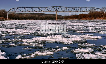 Vue sur un vieux pont sur la rivière enneigée par une journée d'hiver Banque D'Images