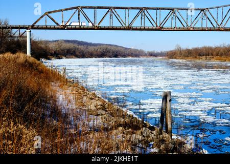 Vue sur un vieux pont sur la rivière enneigée par une journée d'hiver Banque D'Images