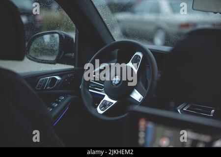 The interior of a luxury BMW X7 car with wet raindrop covered windows Stock Photo