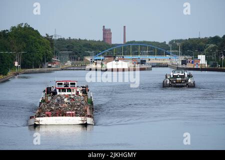 Wusterwitz, Allemagne. 02nd août 2022. Le cargo 'Navigar-4' (l, Szczecin) chargé de ferraille navigue sur le canal Elbe-Havel avec la toile de fond de la tour d'eau de Kirchmöser hors de l'écluse de Wusterwitz. Sur la droite, une barge chargée de sable se dirige vers l'écluse. L'écluse sur la voie navigable fédérale du canal Elbe-Havel, entre Hanovre et Berlin, qui a plus de 100 ans, a été rouverte à la circulation maritime le matin. Crédit : Soeren Stache/dpa/Alay Live News Banque D'Images