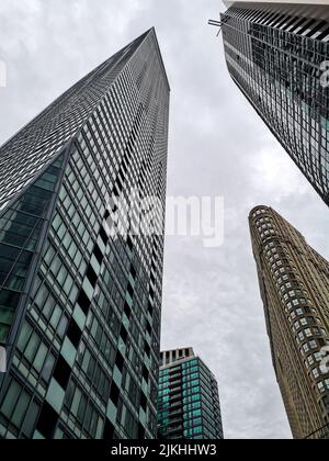 Une vue verticale à angle bas des tours de bureaux hautes contre le ciel nuageux Banque D'Images