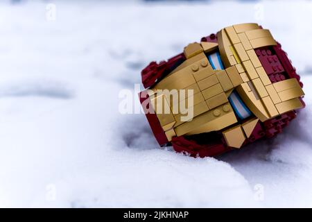 A closeup of a toy Iron Man mask on the snow Stock Photo