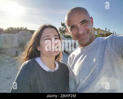 Couple espagnol d'âge moyen attrayant se faisant plaisir ensemble rire et plaisanter avec joie. Banque D'Images