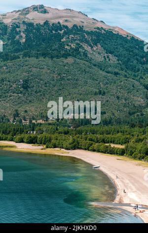 A mesmerizing seascape view surrounded by high dense trees and mountains in the background Stock Photo