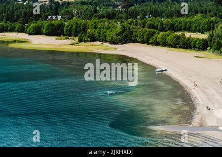 A mesmerizing seascape view surrounded by high dense trees and mountains in the background Stock Photo