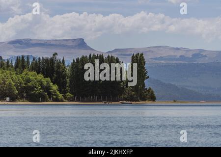 A mesmerizing seascape view surrounded by high dense trees and mountains in the background Stock Photo