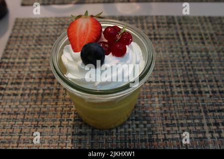 A closeup of homemade pineapple mango sorbet with whipped cream and berries on top. Stock Photo