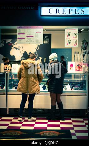 A back shot of a couple standing in a restaurant choosing what to order at night time in Dublin, Ireland Banque D'Images