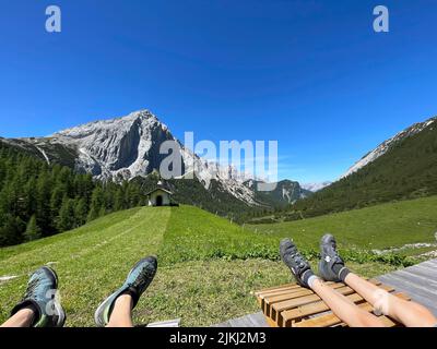 Vue sur les jambes de deux enfants sur la chapelle et Kleiner Lafatscher, Halleranger, randonnée, nature, montagnes, Ciel bleu, activité, parc naturel de Karwendel, Karwendelgebirge, Leutasch, Seefeld, Mösern, Reith, Scharnitz, plateau de Tirols, Tirol, Autriche Banque D'Images