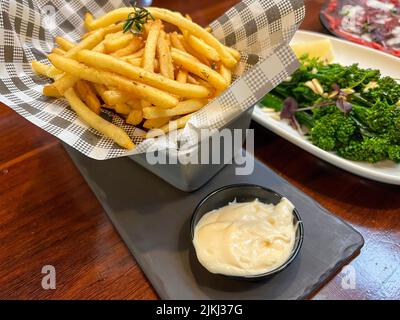 Frites, chips et un plat de brocoli cuit Banque D'Images