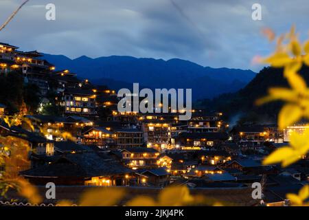 Une belle photo des vieilles maisons traditionnelles dans le village de la minorité ethnique de Langde Miao la nuit, province de Guizhou, Chine Banque D'Images