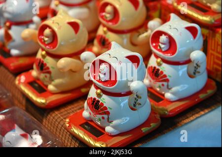 The welcoming cat oriental souvenirs on sale in oriental fair selective in Turin, Italy Stock Photo