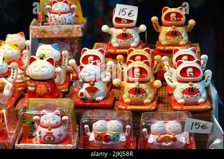 The welcoming cat oriental souvenirs on sale in oriental fair selective in Turin, Italy Stock Photo