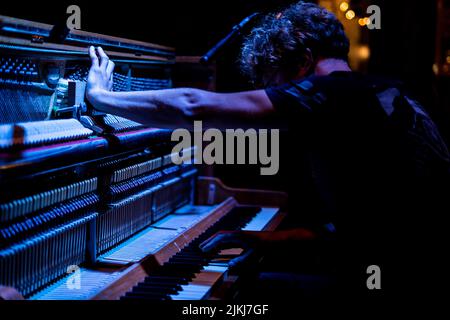 Pianiste masculin jouant sur un piano en bois Banque D'Images