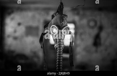 Cliché en échelle de gris d'un masque de gaz respiratoire dans un bâtiment abandonné Banque D'Images