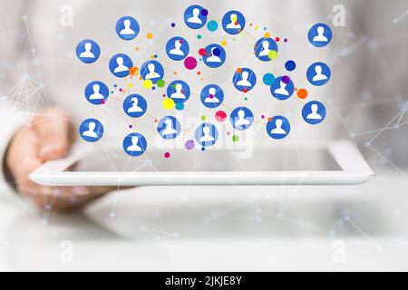 A hologram of interconnected people projecting from a man's tablet. Social media, connectivity, networking concept Stock Photo