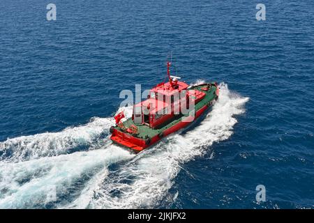 Kusadasi, Turquie - Mai 2022: Vue aérienne d'un bateau pilote quittant un bateau de croisière après l'avoir guidé hors du port Banque D'Images