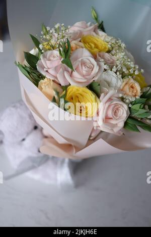 Un adorable ours en peluche et un bouquet de fleurs Banque D'Images