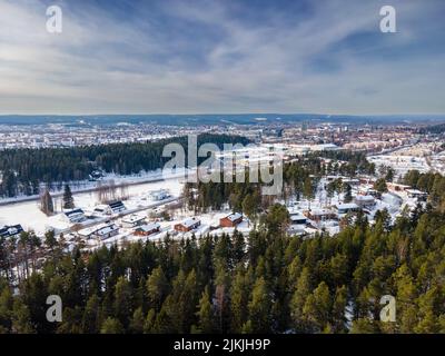 La photo aérienne en grand angle d'une station de campagne enneigée offre une vue entourée de hauts arbres, Skelleftea, Suède Banque D'Images