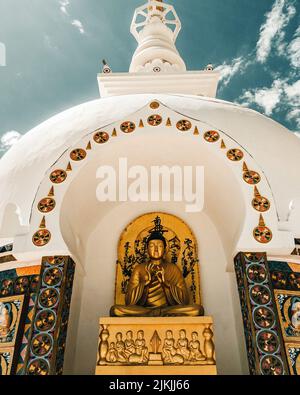 A low angle shot of Shanti Buddhist white-domed stupa under blue bright sky Stock Photo
