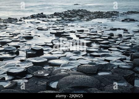 A closeup shot of the water washing basalt rocks at the Giants Causeway in Northern Ireland Stock Photo