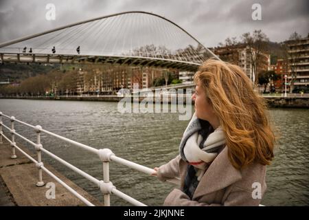 Une belle photo d'une femme caucasienne se tenant près du lac près du pont Zubizuri. Banque D'Images