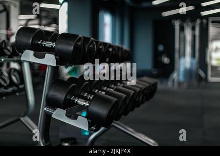 Concept d'équipement sportif. Jeu d'haltères placé sur le rack dans la salle de gym Banque D'Images
