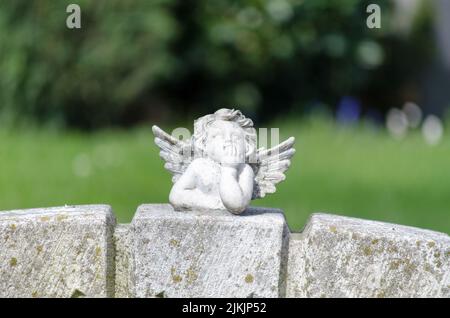 Figurine ange blanc est posé sur une pierre tombale Banque D'Images