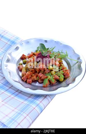 fermer les pois frits, le chou-fleur, la carotte rouge, avec la menthe et la fleur sauvage sous les légumes faits dans la plaque d'acier sur un fond blanc hors foyer. Banque D'Images