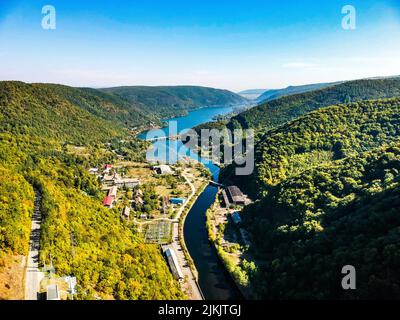 An aerial view of the flowing Lake Tarnita surrounded by the green mountains Stock Photo