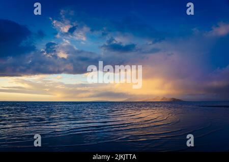 A blue clouds over the sea. Tinted seascape. The light of the sun is reflected in the sea Stock Photo