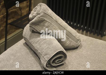 Two gray towels on the soft bed in a massage room Stock Photo