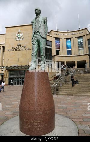 Glasgow, Écosse, Royaume-Uni. Statue à Scotlands Premier ministre Donald Dewar devant le Royal concert Hall.Glasgow, rue Buchanan.Statue de Donald Dewar debout à l'extrémité nord de la rue Buchanan. Donald Dewar était un politicien écossais. En tant que membre du Parti travailliste, il a représenté l'Écosse au Parlement britannique en 1966-1970, puis de nouveau à partir de 1978. Jusqu'à sa mort en 2000, il était le premier ministre de l'Écosse. Sa statue de bronze surplombe Buchanan Street, l'une des plus belles artères de la ville, et se dresse sur les marches de la salle de concert royale. La statue a été dévoilée le 7 mai 2002. Banque D'Images