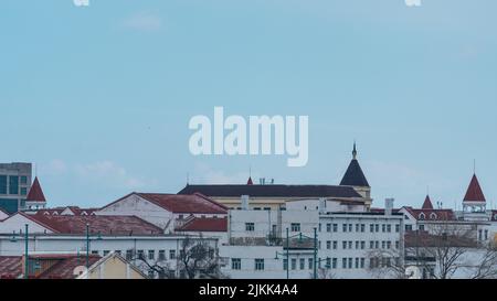 A series of rooftops in a traditional European city with a background of light blue sky Stock Photo