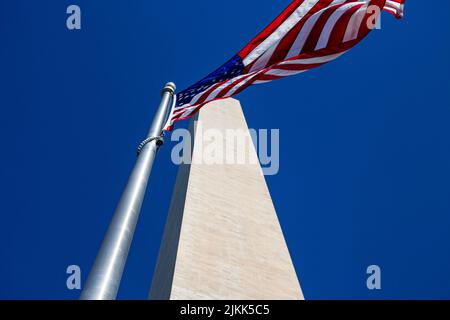 A low angle view of American flag under blue sky Stock Photo