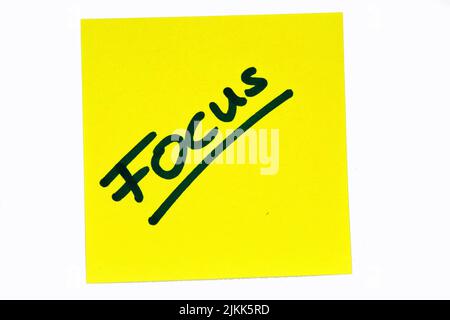 A black colored inspirational motivating quote "Focus" on a yellow post-it over a white background Banque D'Images