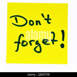 A black-colored motivating quote "Don't forget!" on a yellow post-it over a white background Banque D'Images