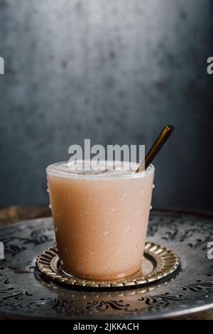 creamy drink cocktail with tamarind soda, nutmeg, cinnamon, cacao nibs, chocolate on wooden barrel with spoon Stock Photo