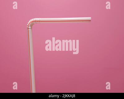 A view of white and red plastic straw isolated on pink background Banque D'Images