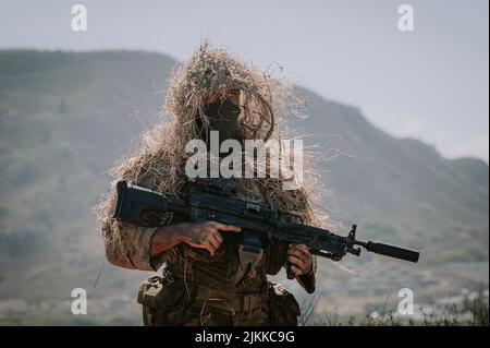 Kaneohe Bay, États-Unis. 01 août 2022. Une équipe de reconnaissance de l'armée australienne portant un costume de ghillie prend position lors d'un raid amphibie pour un exercice multinational d'opérations littorales dans le cadre de la ceinture du Pacifique à la base du corps des Marines Hawaii, 1 août 2022, dans la baie de Kaneohe, à Hawaï. Crédit : Cpl. Djalma Vuong-de Ramos/Forces armées canadiennes/Alamy Live News Banque D'Images