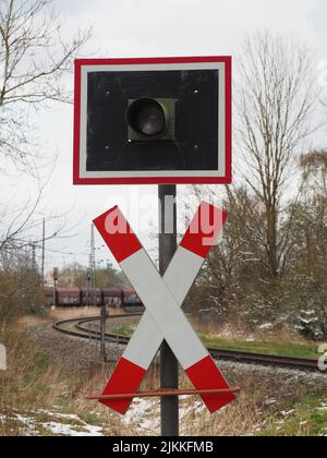 A vertical shot of a sign for not crossing the rails when a train comes Stock Photo