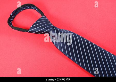 A striped necktie isolated on a red background Banque D'Images