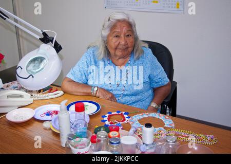 La personne âgée et le membre de la tribu Mojave font la démonstration d'un beadwork traditionnel, fort Mojave California Banque D'Images