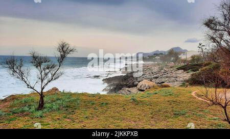 La vue de la mer avec la côte contre le ciel nuageux. Banque D'Images