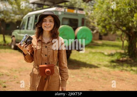 Une femme heureuse en safari à l'aide d'un appareil photo Banque D'Images