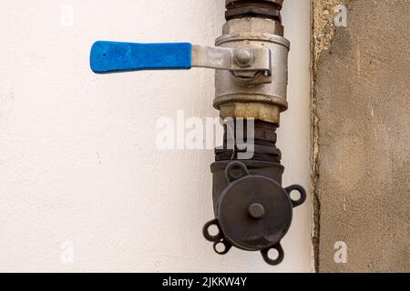 L'ancien robinet à valve avec le tuyau bleu. Banque D'Images